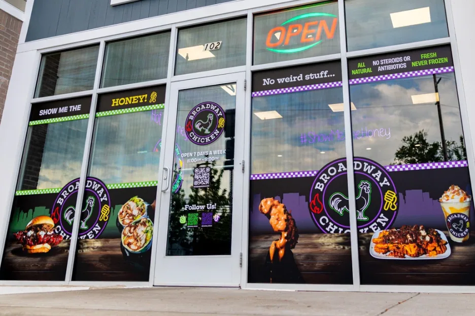 Storefront windows wrapped in Broadway Chicken menu decals