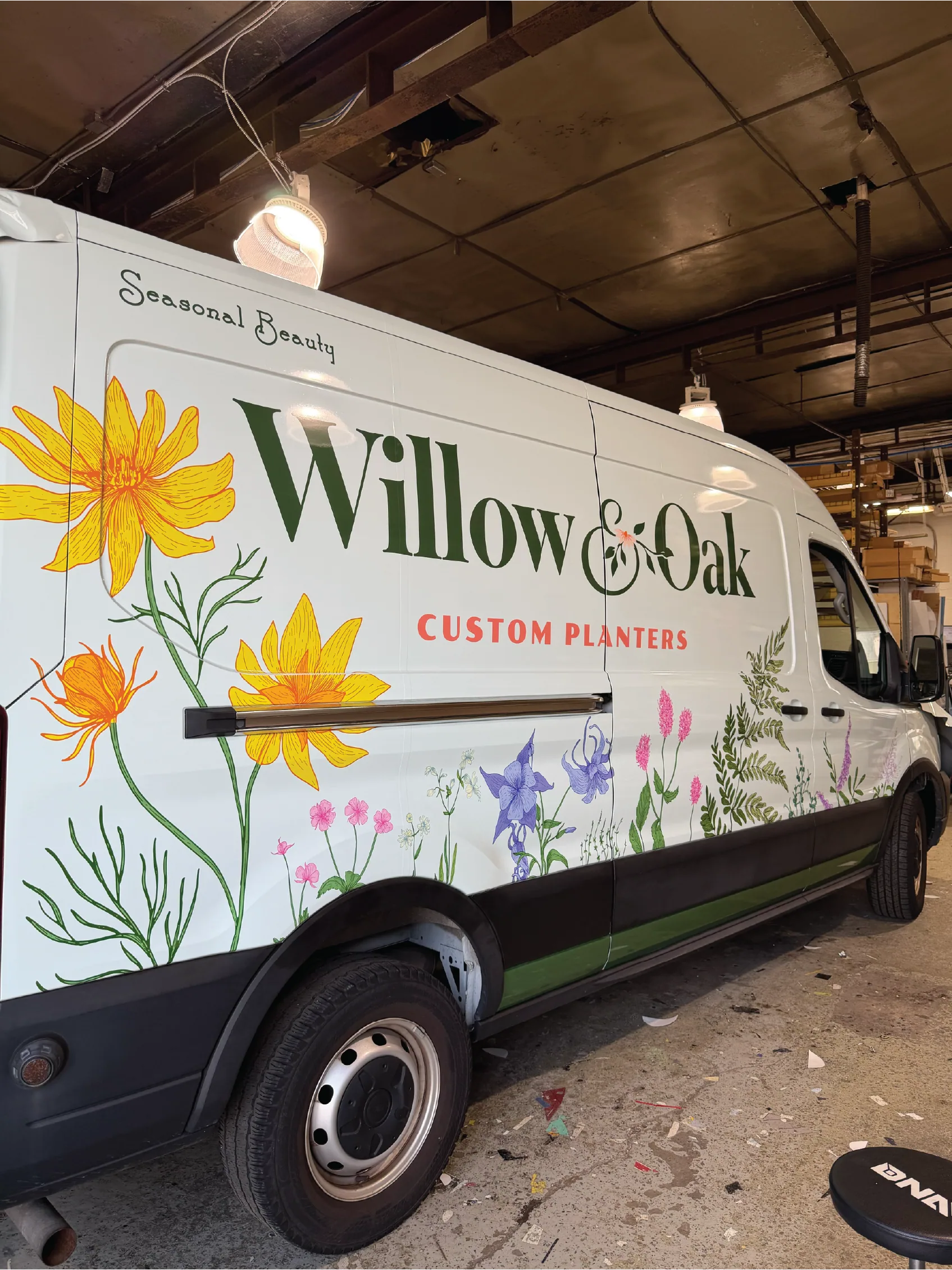 Close-up of the botanical wrap and wordmark on the van side panel
