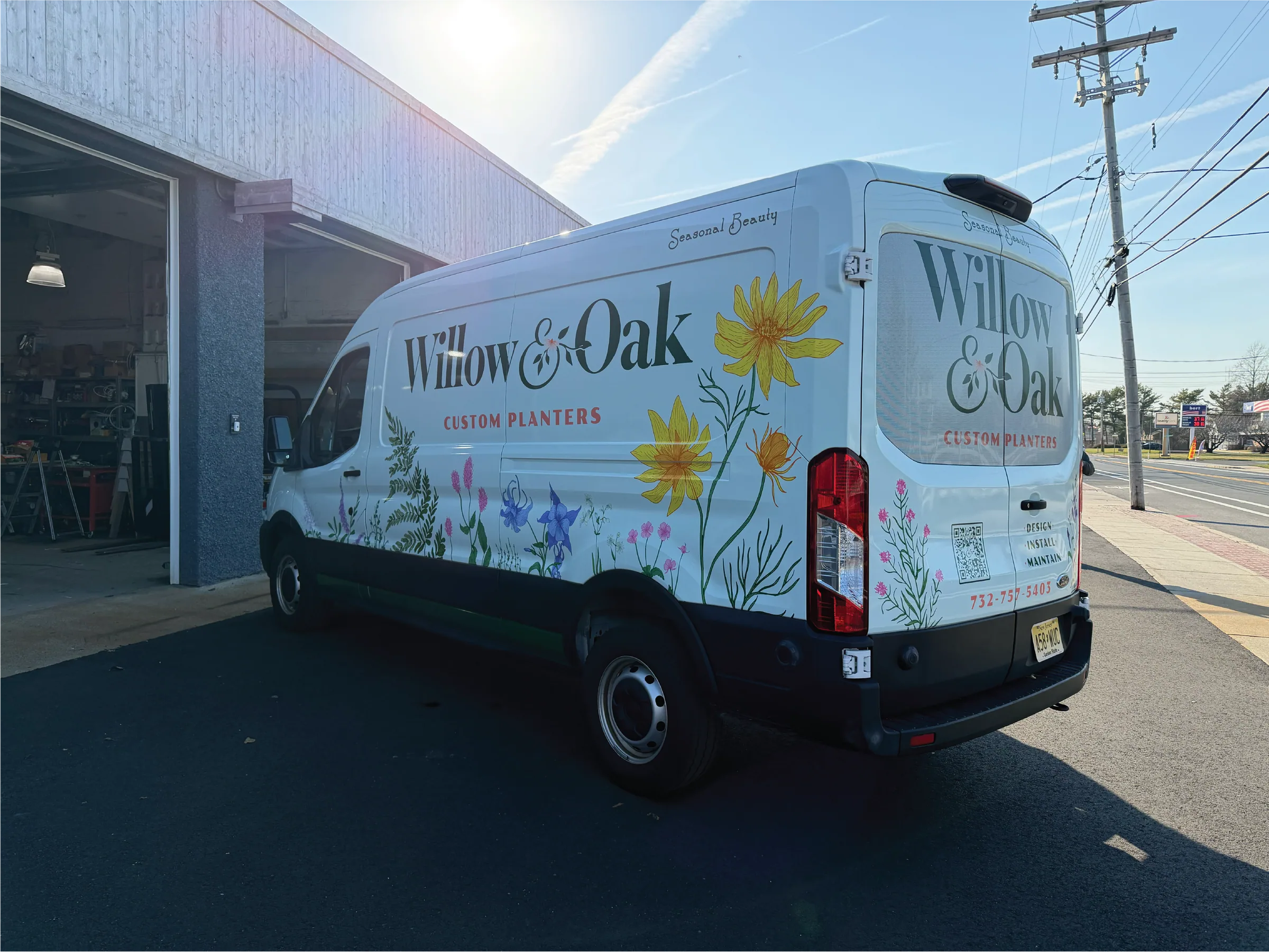 Wrapped Willow & Oak van parked outside a building